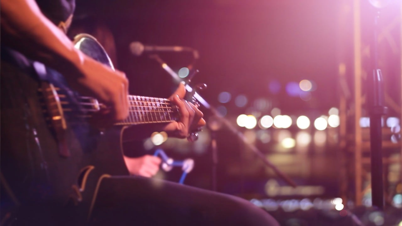 Man playing a guitar at Le Noir, a supper spot after visiting the best nightclubs in Singapore