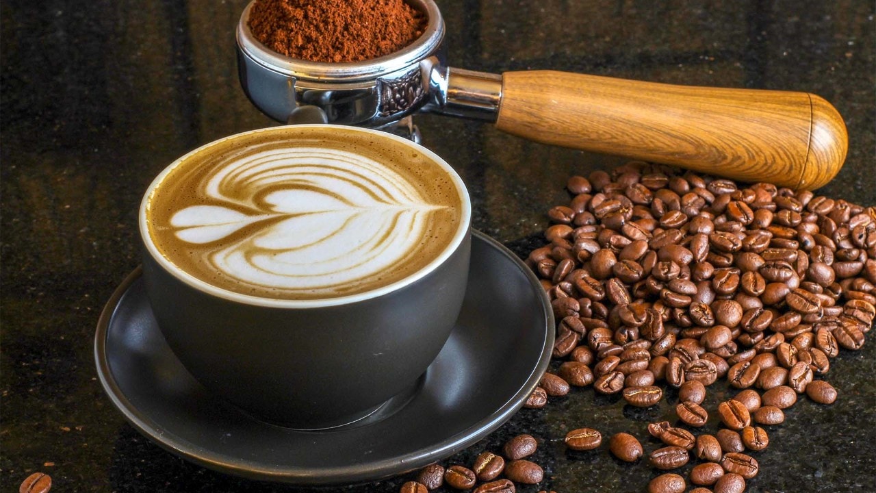Cup of flat white with latte art, coffee beans and powder